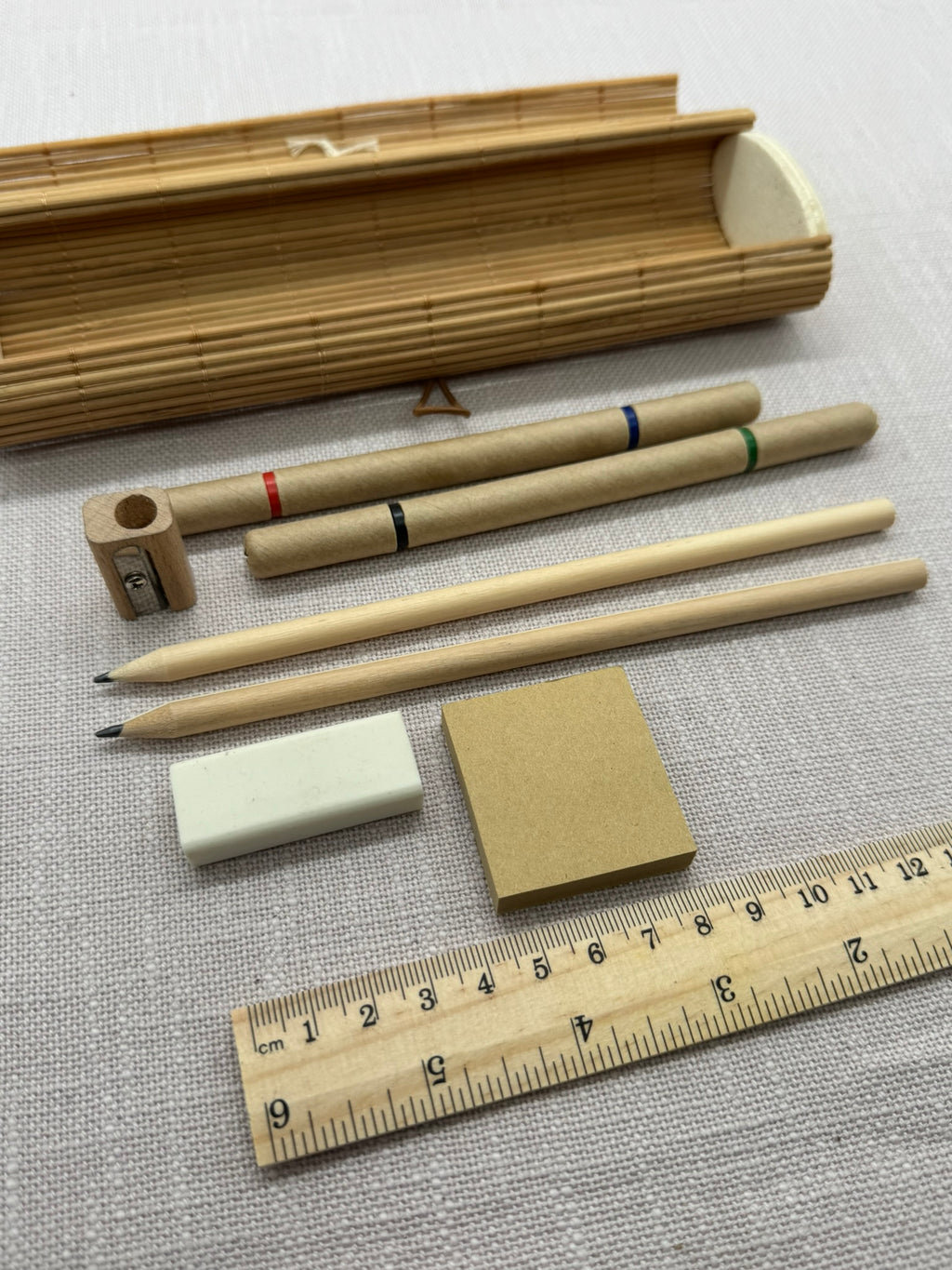 Naturbelassenes Schreibset aus Holz und Karton, mehrere Schreibwaren im Holzetui. 