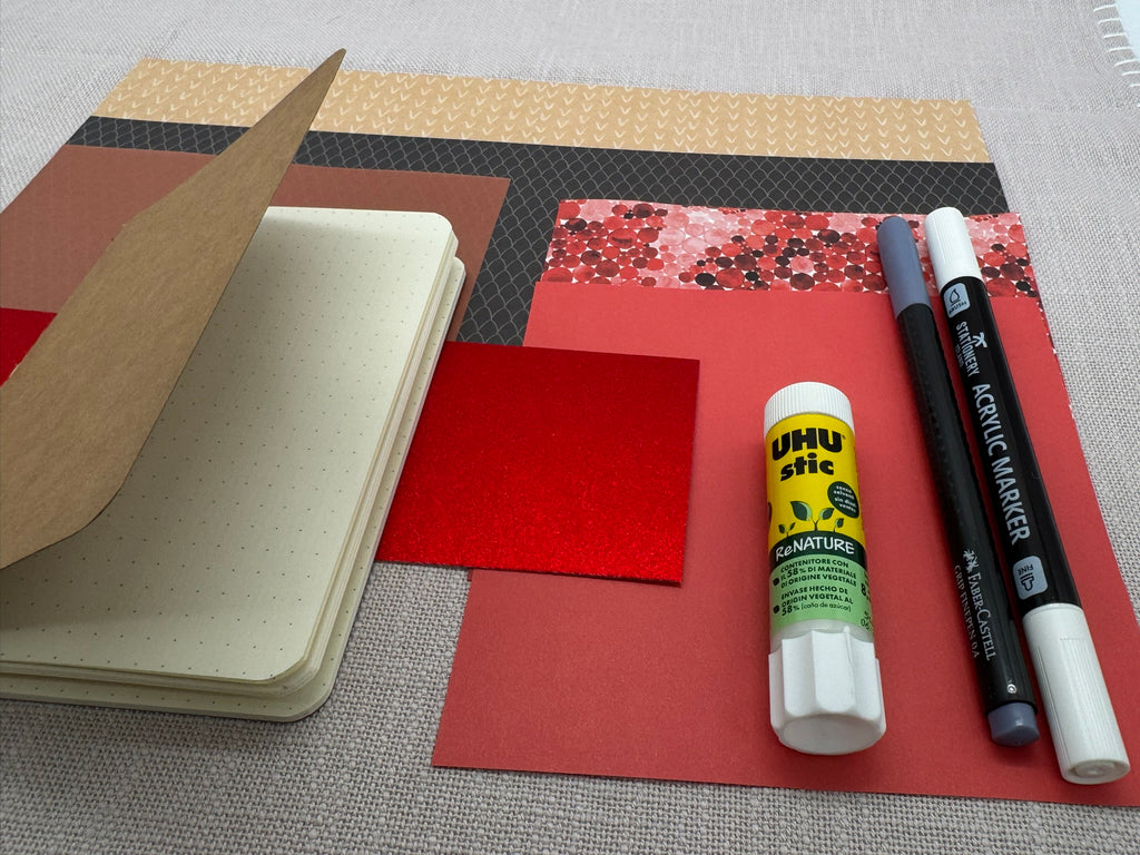 Bastelset mit Notizbuch, Stiften und Papier in verschiedenen Farben.