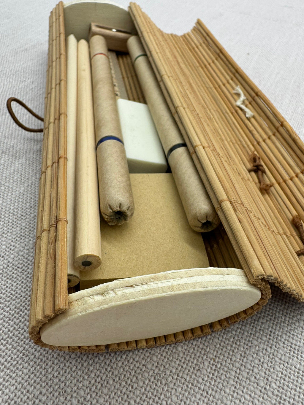 Stifte, Bleistifte, Radierumi, Anspitzer und Notizzettel liegen in einem geöffneten Etui. Alles ist in Beige, Naturfarben gehalten.