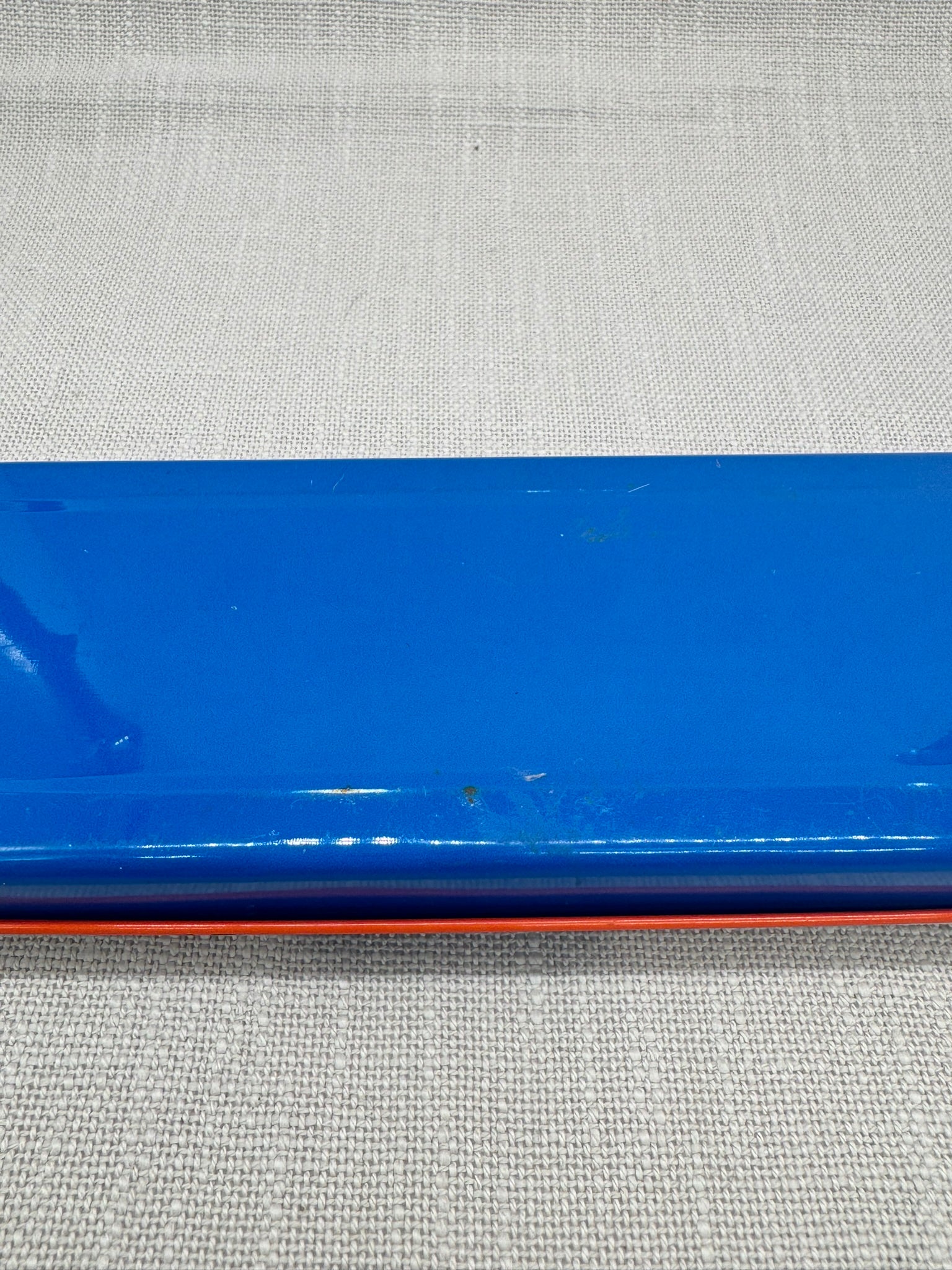 Kratzer in der blauen Farbe auf der Unterseite der Dose.