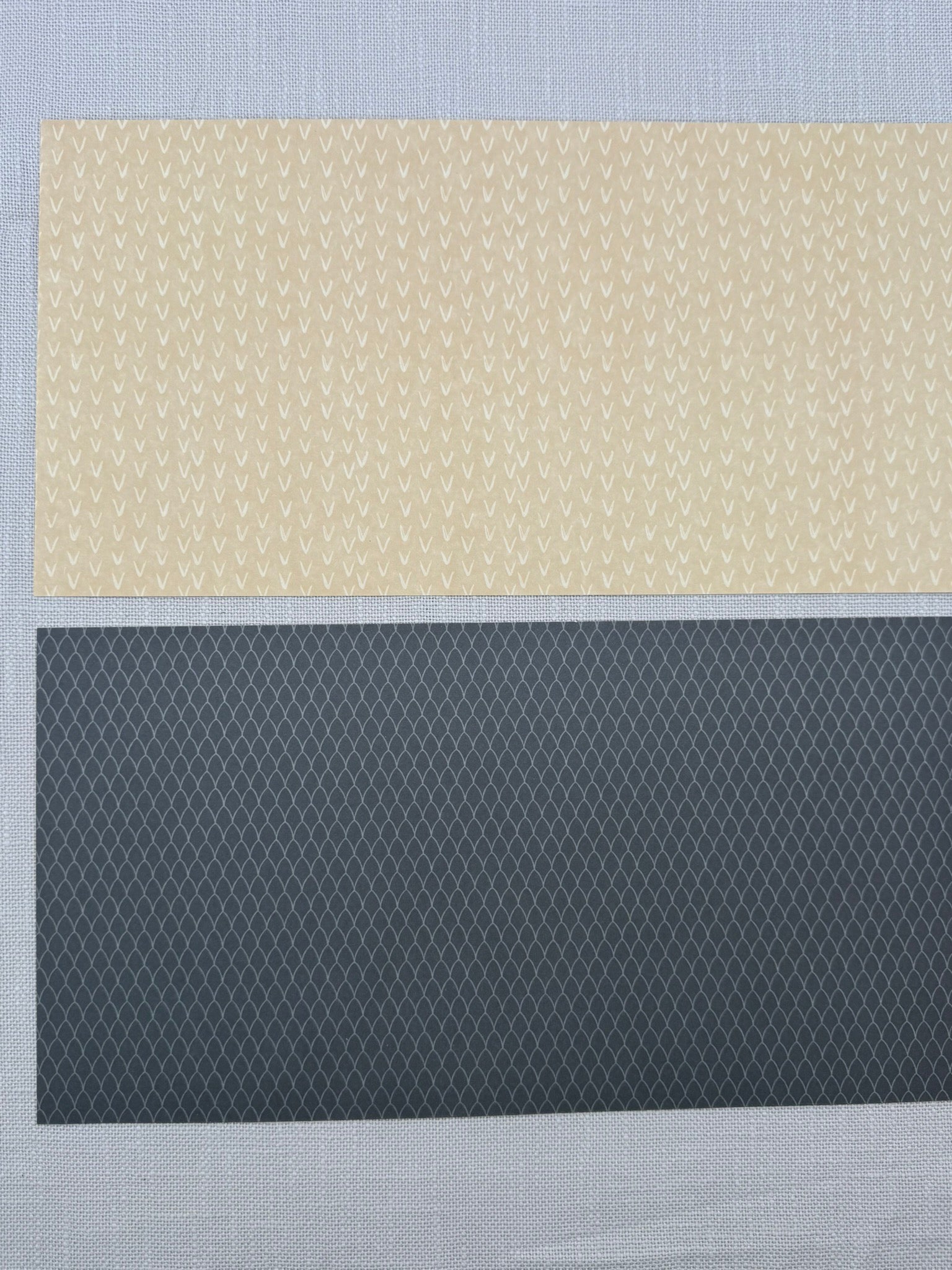zwei Stück Bastelpapier mit feinem Muster in Beige und Schwarz