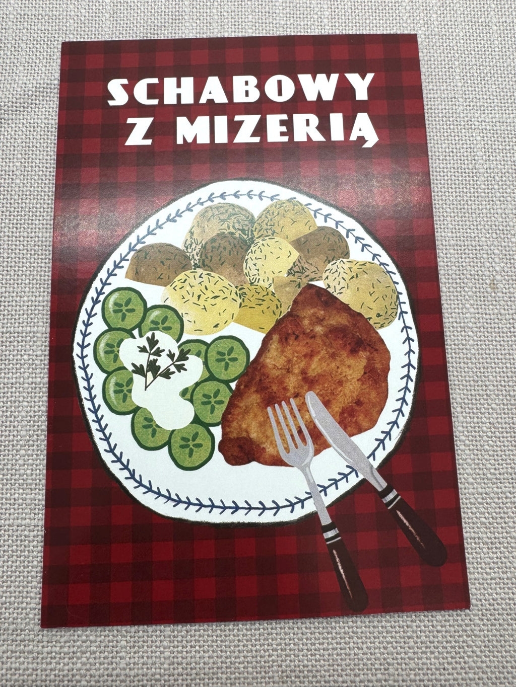 Postkarte Schnitzel mit Kartoffeln und Gurkensalat auf rotem Hintergrund