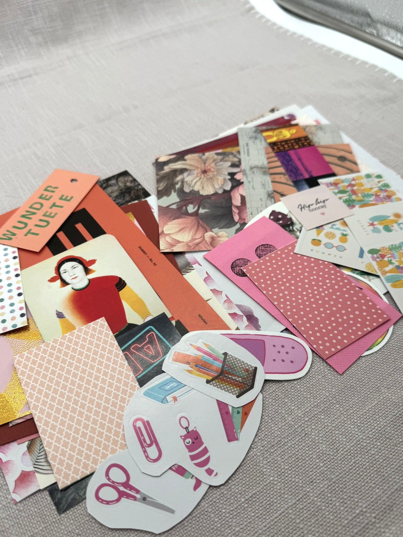 Eine Auswahl von diversen Designpapieren auf einem Haufen: Etiketten, Sticker, Ausschnitte aus Zeitschriften, Designpapier, Geschenkpapier.