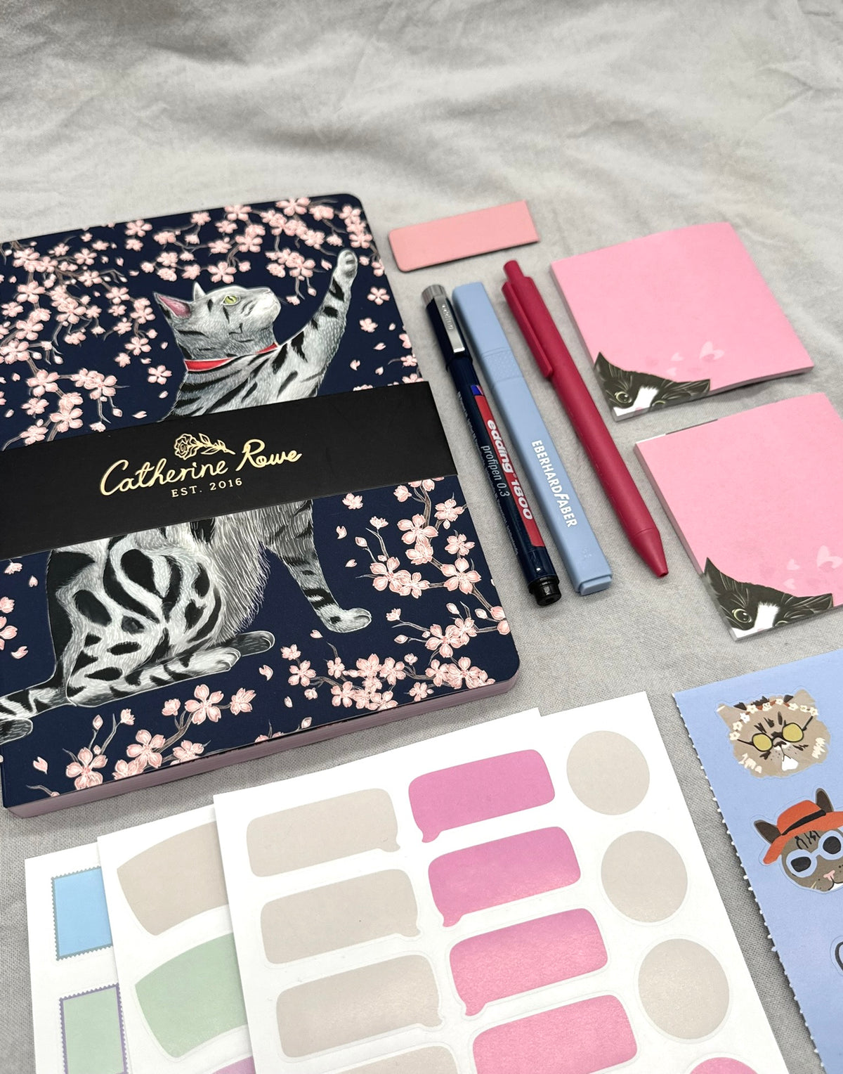 Schreibset mit Notizbuch, Stiften und Stickern in Blau und Pink.