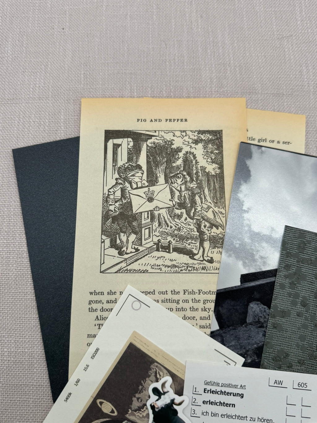 Diverse Papierstücke aus dem Set übereinander: Buchseiten aus "Alice im Wunderland", Tapetenreste, Fotos, Etiketten. 