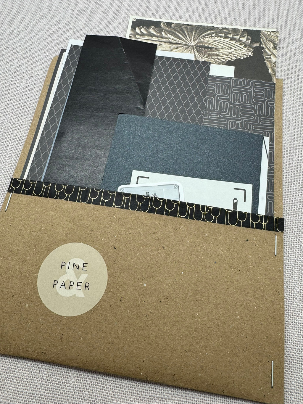 Ein Umschlag aus Kraftpapier mit diversen Papierstücken für Basteln, Scrapbooking, Collagen