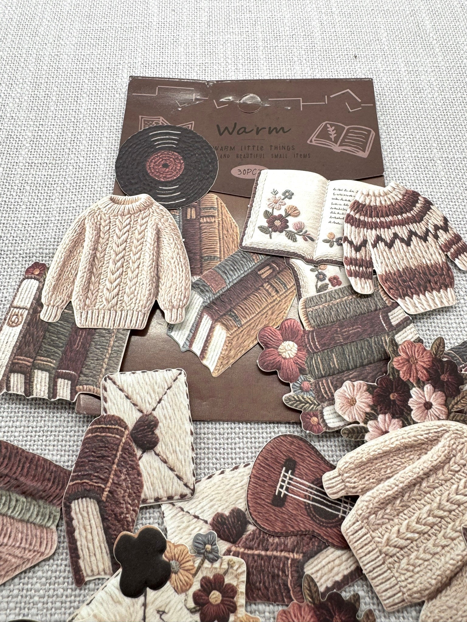Diverse Sticker verteilt auf einem hellen Hintergrund: Cremeweiß, Braun, Dunkelrot, Dunkelgrün, Beige. 