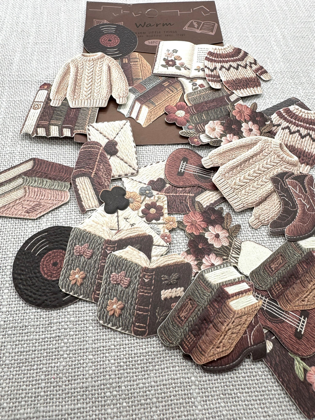 Diverse Sticker verteilt auf hellem Hintergrund. Verschiedene herbstliche Motive, die wie gestrickt aussehen. 