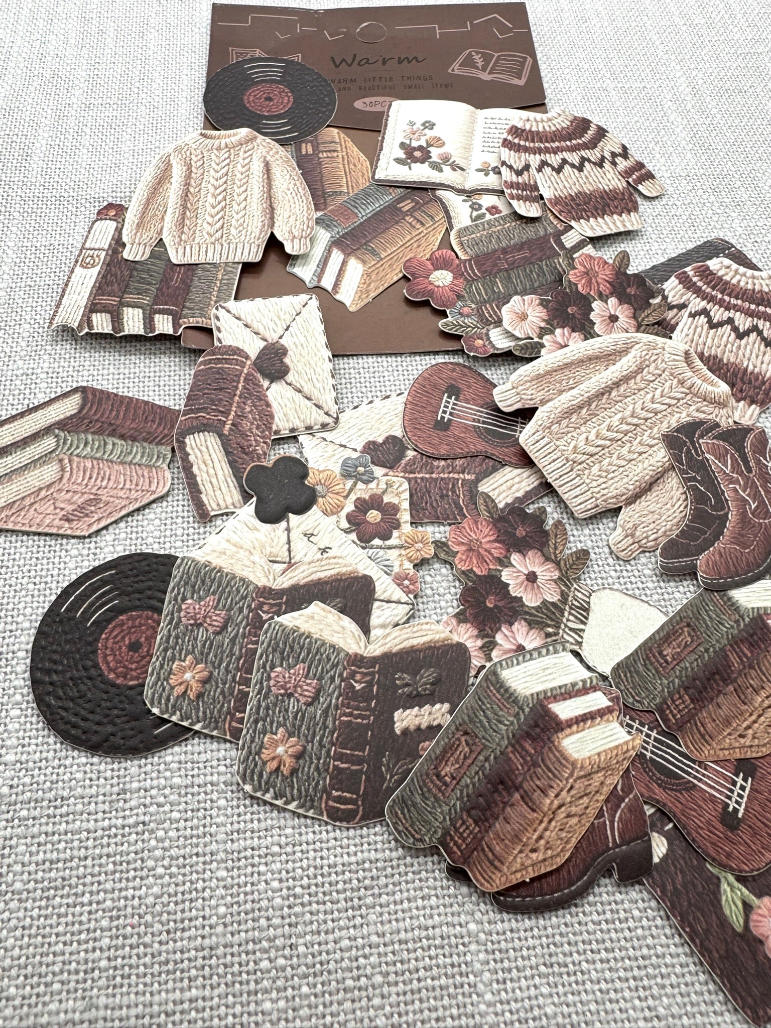 Diverse Sticker verteilt auf hellem Hintergrund. Verschiedene herbstliche Motive, die wie gestrickt aussehen. 