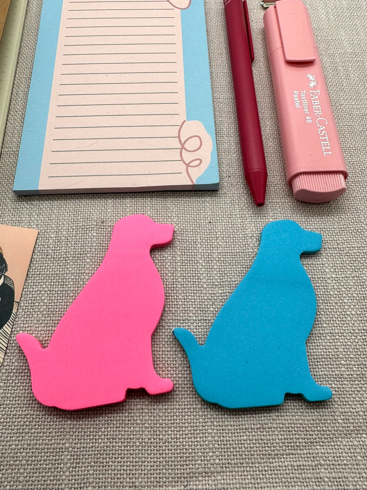 Nahaufnahme von Post-Its in Form einer Hunde-Silhouette. Ein Block ist Neonpink, der andere Blau. 