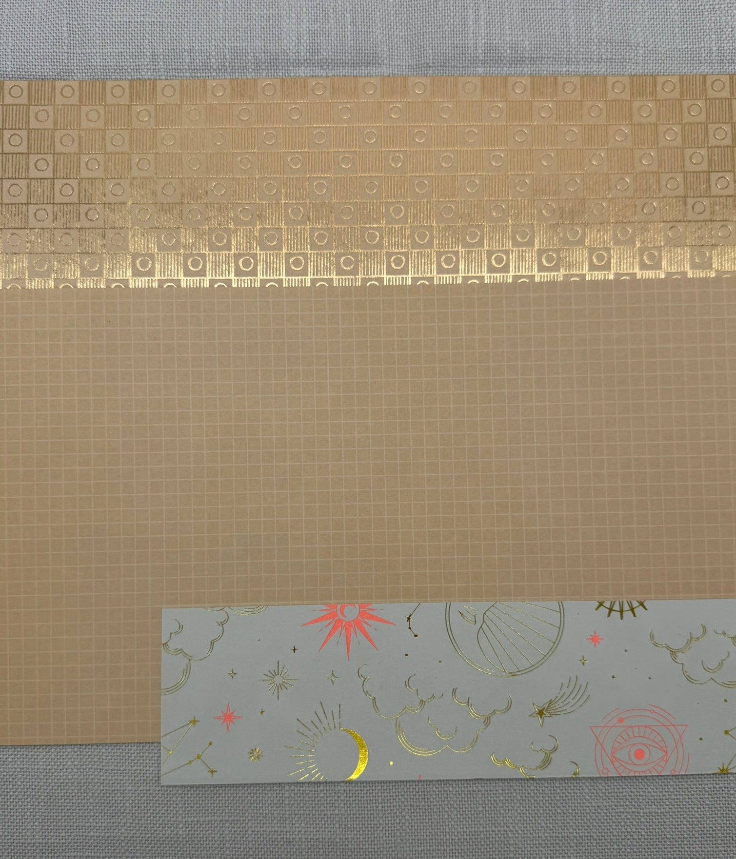 3 verschiedene Designpapiere übereinander: beide mit Muster einmal glnzend, einmal matt und das Horoskop-Designpapier in Gold-Weiß mit Pinken Akzenten