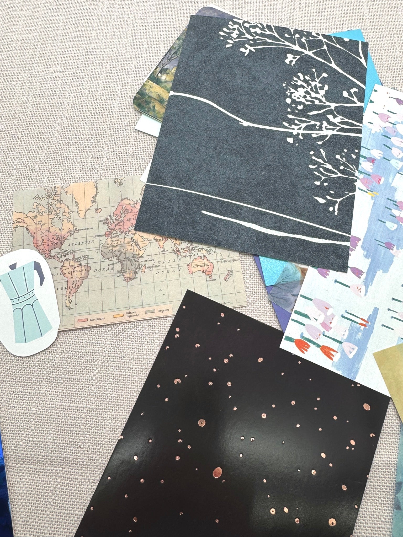 verschiedene Papierstücke: Tapete, Bastelkarton, Landkarte, Sticker, eine Klanederseite