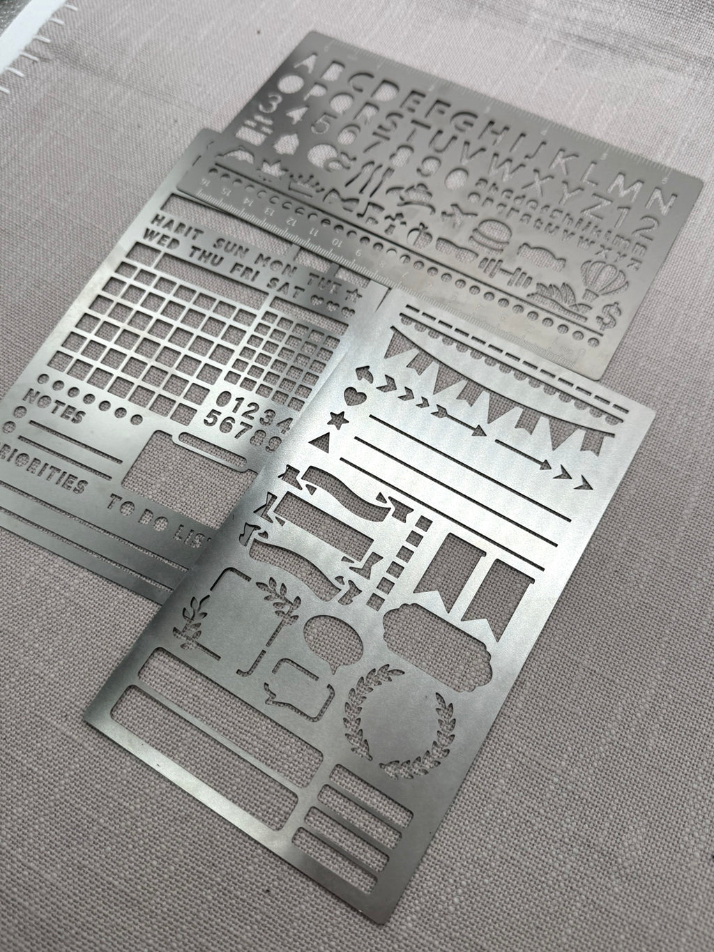Drei Metallschablonen mit unterschiedlichen Motiven.