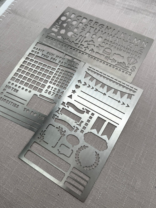 Drei Metallschablonen mit unterschiedlichen Motiven.